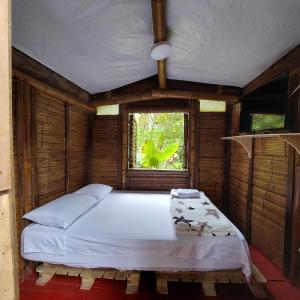 a bed in a room with a window at Hostal La Pijaraña in Salento