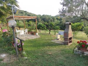 un cortile con griglia, tavolo e sedie di Zefiro Casa Vacanze ad Ascea