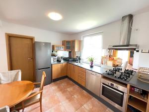 a kitchen with a table and a stove top oven at Dom Kapitana in Mikołajki +13 photos