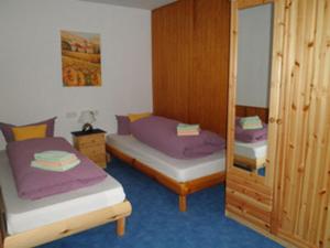 a small room with two beds and a mirror at Ferienhäusle Sonnenblume Titisee in Titisee-Neustadt