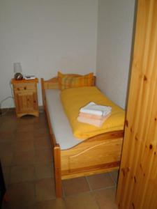 a small bed in a room with yellow sheets at Ferienhäusle Sonnenblume Titisee in Titisee-Neustadt