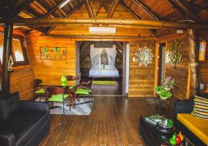 een woonkamer met een bed in een houten hut bij Imagine Beach in Puerto Colombia