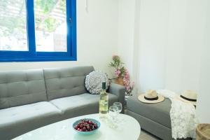 a living room with a couch and a table with a bottle of wine at Sunset Home Crete in Paránimfoi