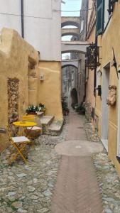 een steeg met een tafel en een tafel en stoelen bij Federico II - Rooms and Breakfast in Borgio Verezzi