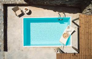 uma vista superior de uma piscina sobre uma parede em Niva Pool Suites em Dhriopís