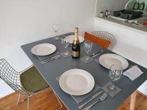 a table with plates and glasses and a bottle of champagne at Luxury Private Mews Modern Apartment in the City in London