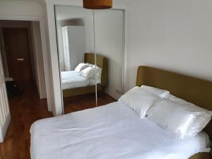 a bedroom with a white bed and a mirror at Luxury Private Mews Modern Apartment in the City in London