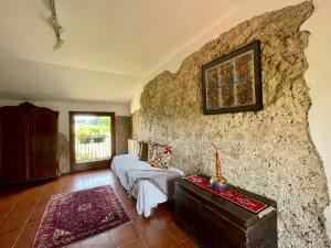 Colline di Luce في San Pietro di Feletto: غرفة معيشة مع أريكة وجدار حجري