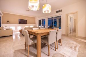 a dining room with a wooden table and chairs at Villa Bahía in Corralejo