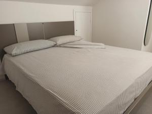 un letto bianco con due cuscini sopra di stefy bilo fronte mare ad Alba Adriatica