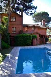 una piscina frente a una casa en Vacances Dorado, en Pinamar