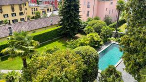 une vue aérienne d'une piscine dans un jardin dans l'établissement Villa Magnolia - High standing floor, à Locarno