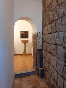 una habitación con una pared de ladrillo y una pintura en la pared en Foresteria, en Tuscania