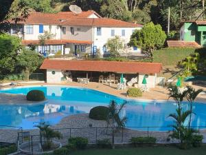 a large swimming pool in front of a house at Apartamento em Itaipava - Petrópolis in Petrópolis