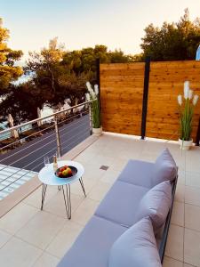 a patio with a couch and a table at Zlatni Rat Beach Resort in Bol