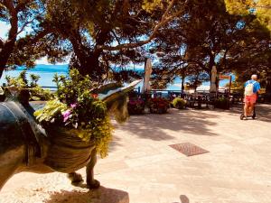 a statue of a fire hydrant with flowers on it at Zlatni Rat Beach Resort in Bol
