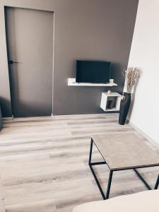 a living room with a table and a tv at Pavasario g. apartamentai in Mažeikiai