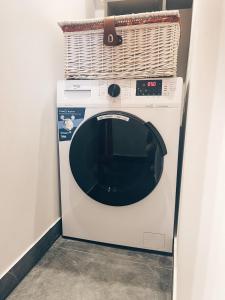 a washing machine with a basket on top of it at Pavasario g. apartamentai in Mažeikiai