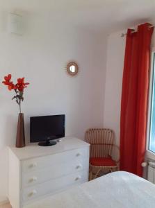 um quarto com uma cómoda e uma televisão em Appart très cosy et confortable à Amélie les Bains em Amélie-les-Bains-Palalda