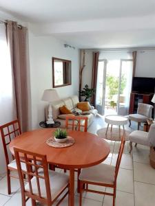 uma sala de estar com mesa e cadeiras em Appart très cosy et confortable à Amélie les Bains em Amélie-les-Bains-Palalda