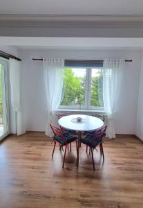 ein Esszimmer mit einem Tisch, Stühlen und einem Fenster in der Unterkunft Dwupokojowy Apartament z widokiem na kanał Augustowski in Augustów