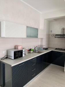 a kitchen with a microwave on a counter at Pensiunea DeeaMar in Năvodari