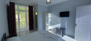 a white room with stairs and a tv on the wall at Guest House Marineza in Gonio