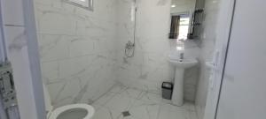 a white bathroom with a toilet and a sink at Guest House Marineza in Gonio +42 photos
