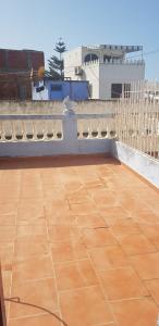 einen Balkon mit einer Bank und Fliesenboden in der Unterkunft Appartement 2 éme étage dans la médina kédima in Asilah