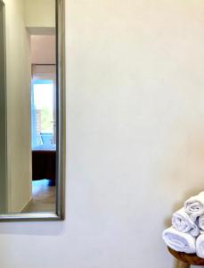 a mirror on a wall next to a pile of towels at Dimora delle Tonnare in Favignana