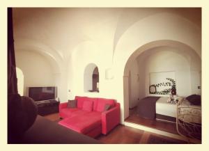 a bedroom with a bed and a red couch at Birbiciù mare in Pantelleria