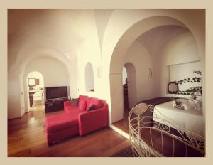 a living room with a red couch and a bed at Birbiciù mare in Pantelleria