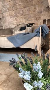 uma cama com um cobertor azul e algumas flores em Trulli Manuela (il fragno) em Locorotondo
