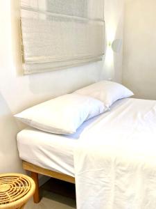 a bed with two white pillows and a window at Dimora delle Tonnare in Favignana
