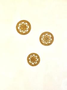 a group of three gold rings on a white wall at Dimora delle Tonnare in Favignana