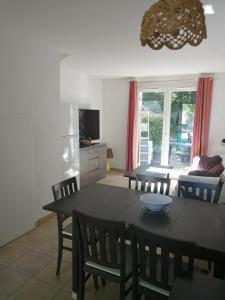 una sala da pranzo e un soggiorno con tavolo e sedie di Agréable duplex équipé au Domaine d'Albret a Barbaste