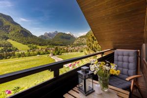 a balcony with a chair and a view of mountains at Rož'ca apartments with mountain view in Mojstrana