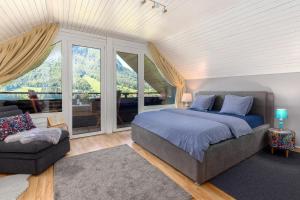 um quarto com uma cama, um sofá e janelas em Rož'ca apartments with mountain view em Mojstrana