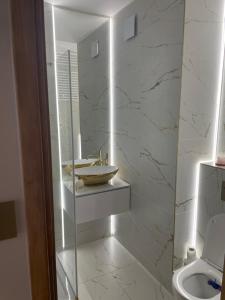 a white bathroom with a sink and a toilet at Apartament Lili Słoneczne Tarasy in Dziwnówek +17 photos