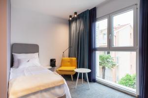 a bedroom with a bed and a chair and a window at Boutique hotel Lili in Rovinj
