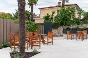 a patio with a table and chairs and a fence at Boutique hotel Lili in Rovinj