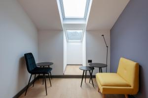 a living room with a yellow chair and two tables at Boutique hotel Lili in Rovinj