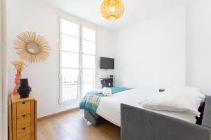 ein weißes Schlafzimmer mit einem Bett und einem Fenster in der Unterkunft t2 Catalans in Marseille