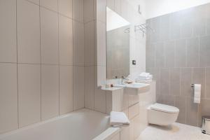 a bathroom with a tub and a toilet and a sink at Boutique hotel Lili in Rovinj