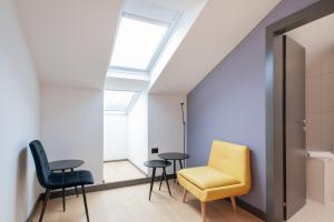a room with a yellow chair and two tables at Boutique hotel Lili in Rovinj