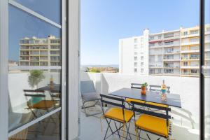 einen Balkon mit einem Tisch und Stühlen sowie Blick auf ein Gebäude in der Unterkunft t2 Catalans in Marseille