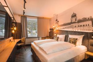um quarto de hotel com duas camas e uma escrivaninha em Am Paulusbogen em Passau
