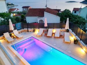 a swimming pool with chairs and a table and a pool at Vacation house with heated swimming pool 70 meters from the beach-Bobanac in Ražanj