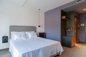 a bedroom with a large bed with white sheets at Boutique hotel Lili in Rovinj