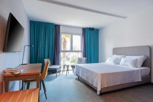 1 dormitorio con cama, escritorio y ventana en Boutique hotel Lili, en Rovinj